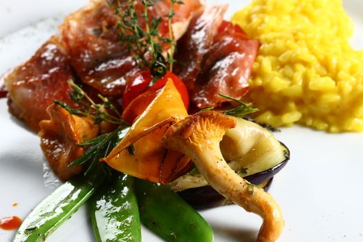Extreme close up of dish with meat, yellow rice, mushrooms. Nice display of gourmet food. fine gourmet food.