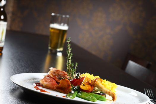 close up of a dish with meal, rice and mushrooms and a beer in background. a real life style meal