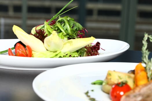 a good meal with a salad on a restaurant setting with green salad on a plate