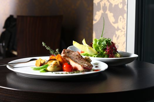 good food - tasty food. a good meal with meat and tomato on a restaurant background