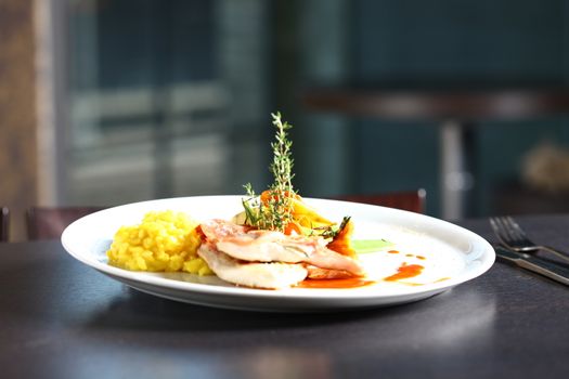 Extreme close up of dish with meat, yellow rice, mushrooms. Nice display of gourmet food. With a windows in the background