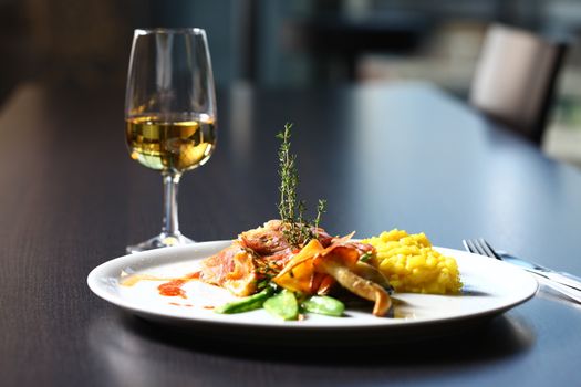 a good meal with wine. close up of a dish with meal, rice and mushrooms and a glass of wine in background.