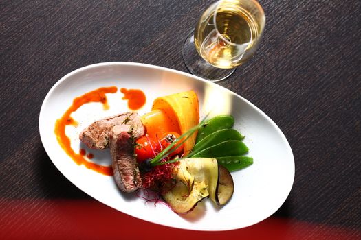 close up of a dish with meal, rice and mushrooms and a glass of wine in background. Shot from above with copy space and oval plates