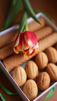 Shortbread cookies and tulips. Gift to the woman. Russian Sweets - oreshki cookies and tubes - vertical photo - good format for stories