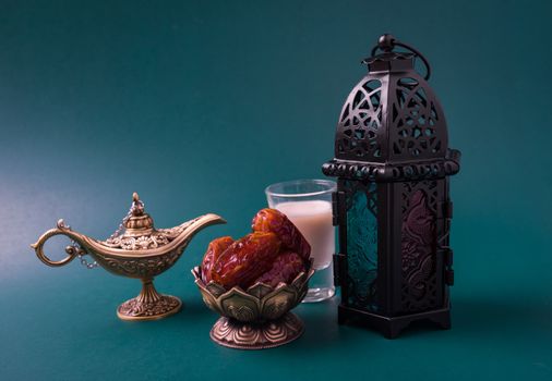 Ramadan Kareem fasting Food Concept, Bronze plate dates, milk, and lantern Aladdin lamp decoration, eid Arabian Muslim religious festival on a dark green background with copy space for text