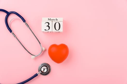 Doctor's Day concept, flat lay top view, equipment medical red heart and stethoscope on pink background, care patient in hospital with copy space for text