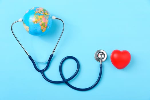 World health day concept, Stethoscope, globe and red heart on blue background with copy space. Global health care