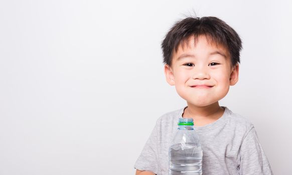 Closeup Asian face, Little children boy drinking water from Plastic bottle on white background with copy space, health medical care