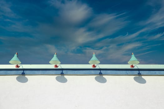 Four old fashioned lamps on a white stucco building