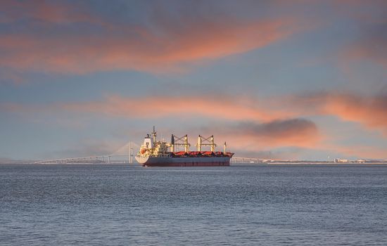 A dredging ship anchored in a harbor and working on the shipping lane