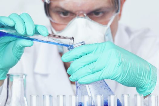 Mature male researcher carrying out scientific research in a lab, Chemistry experiments close up