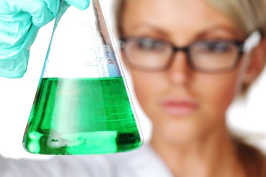 Woman conducting a chemical experiment with green liquid in beaker