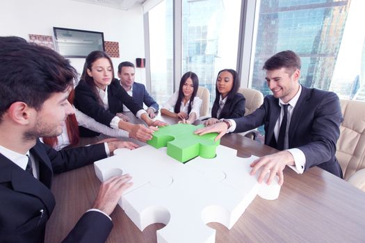 Business people with jigsaw puzzle, putting last green piece, success support help concept