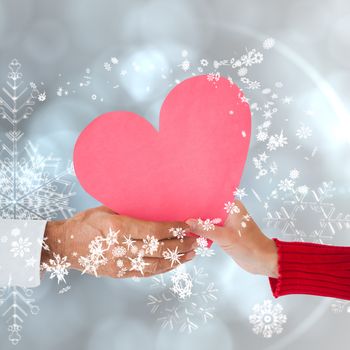 Couple holding heart against silver snow flake pattern design