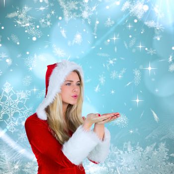 Pretty girl in santa outfit blowing against blue snow flake pattern design