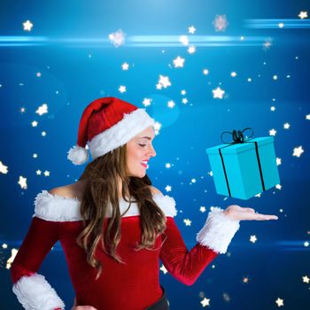 Pretty girl in santa costume holding hand out against bright star pattern on blue