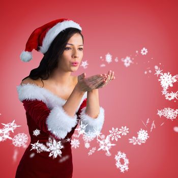 Pretty girl in santa outfit blowing against red vignette
