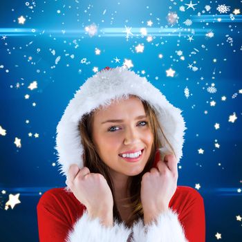 Sexy santa girl smiling at camera against bright star pattern on blue