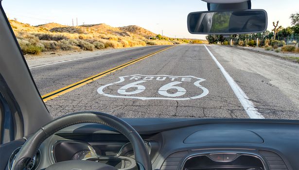 Looking through a car windshield with view of the Historic Route 66, with pavement sign in California, USA
