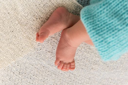 Closeup of a newborn baby feet with beautiful selective focus. Concept for maternity and tenderness
