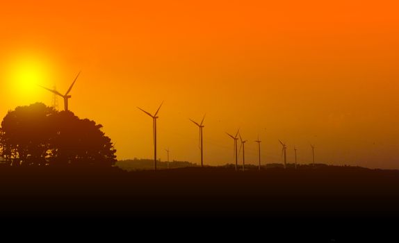 Wind turbines silhouette with sunset at the khao kho park, Thailand.