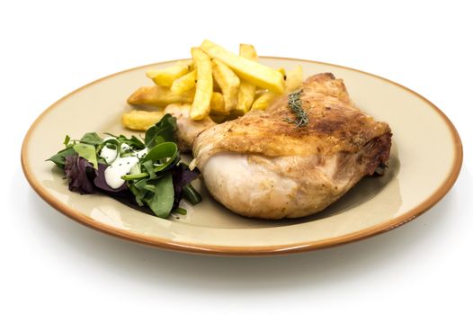 Roasted chicken leg with fries and vegetables on white background
