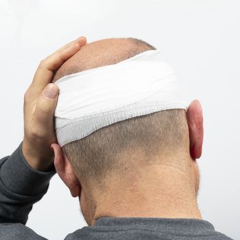 A middle-aged man with a bandaged head