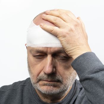 A middle-aged man with a bandaged head