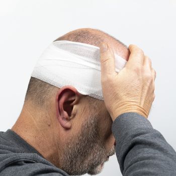 A middle-aged man with a bandaged head