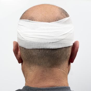 A middle-aged man with a bandaged head