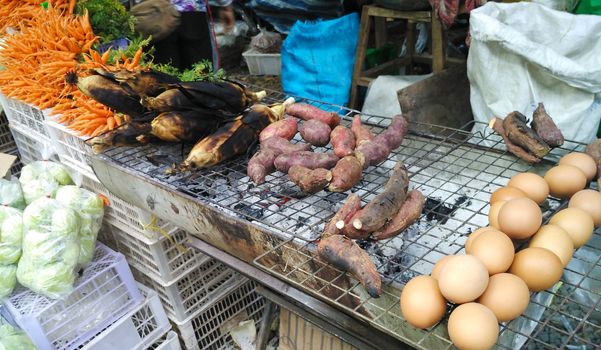Roasted sweet potatoes  and corn at street food in Thailand.