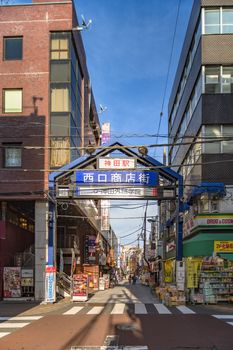 Blue metal entrance gate of the shopping street from the west exit of Kanda Station on the Yamanote Line. The street extends over 300 meters and has no less than 100 shops.