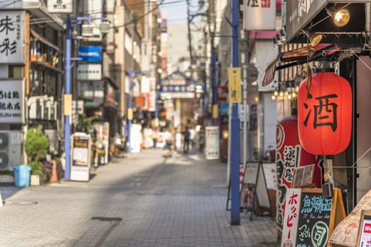 Red rice paper lantern with japanese kanji sake which mean Alcool on the front of an restaurant in the shopping street from the west exit of Kanda Station on the Yamanote Line. The street extends over 300 meters and has no less than 100 shops.