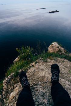 Person sitting on the edge of a cliff