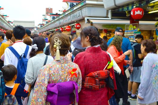 Young girl wearing Japanese kimono standing in front of Sensoji Temple in Tokyo, Japan. Kimono is a Japanese traditional garment. 