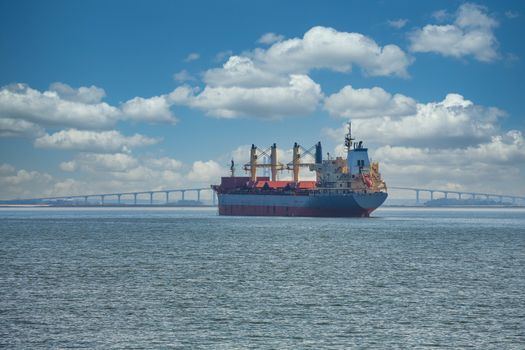 A dredging ship anchored in a harbor and working on the shipping lane