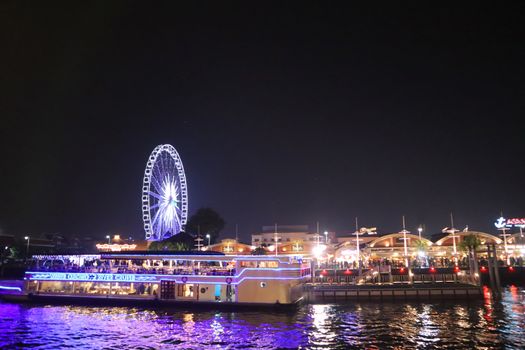 A trip boat at the embankment at Chao Phraya River in Bangkok city. cityscape in the evening. Nigt life in asia