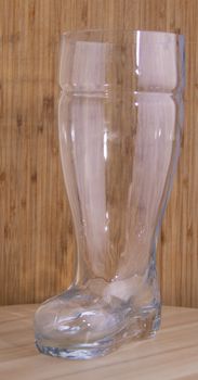 An Empty boot beer glass in a wooden board in wooden background