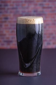 A Guinness dark Irish dry stout beer glass that originated in the brewery in dublin vertical view