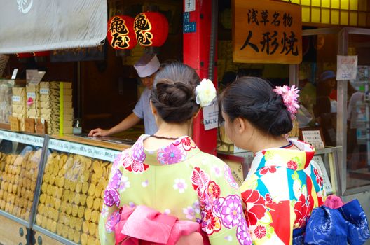 JAPAN, TOKYO, NOV 18 2016. People buy Japanese famous dessert from a food stall at Nakamise Dori shopping street way to Asakusa Sensoji-ji Temple, Tokyo, Japan. 