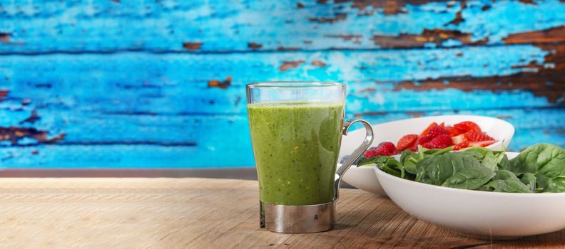 close up of healthy food and fruit with copy space. Blue wood background with a glass of green smoothy