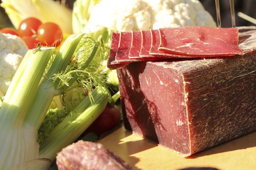 Food ready for an outdoor celebration in Switzerland. Raw meat with vegetables. sliced of meat ready for snacks