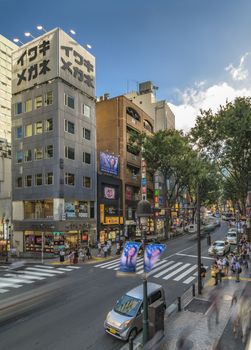 Dogenzaka shopping street leading to Shibuya Crossing Intersection in front of Shibuya Station on a bright day blue sky.