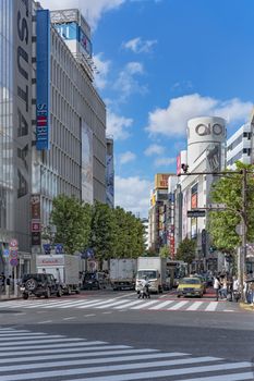 Shibuya Crossing Intersection in front of Shibuya Station on a bright day blue sky.