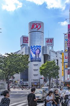 Shibuya Crossing Intersection in front of Shibuya Station on a bright day blue sky.