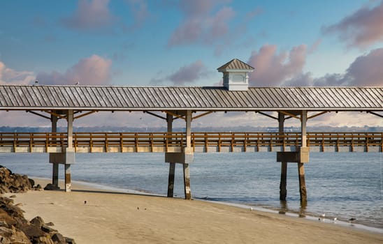 An old wood and concrete pier over empty beach