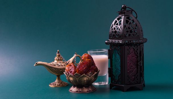 Ramadan Kareem fasting Food Concept, Bronze plate dates, milk, and lantern Aladdin lamp decoration, eid Arabian Muslim religious festival on a dark green background with copy space for text