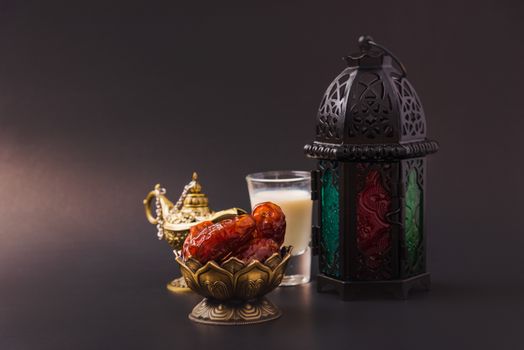 Ramadan Kareem fasting Food Concept, Bronze plate dates, milk, and lantern Aladdin lamp decoration, eid Arabian Muslim religious festival on a black background with copy space for text
