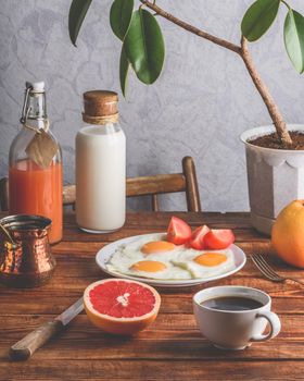 Healthy breakfast with turkish coffee, milk, juice, fried eggs, fruits and vegetables