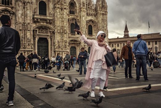 MILAN, ITALY 10 MARCH 2020: Tourist posing for a photo in front of the Milan cathedral